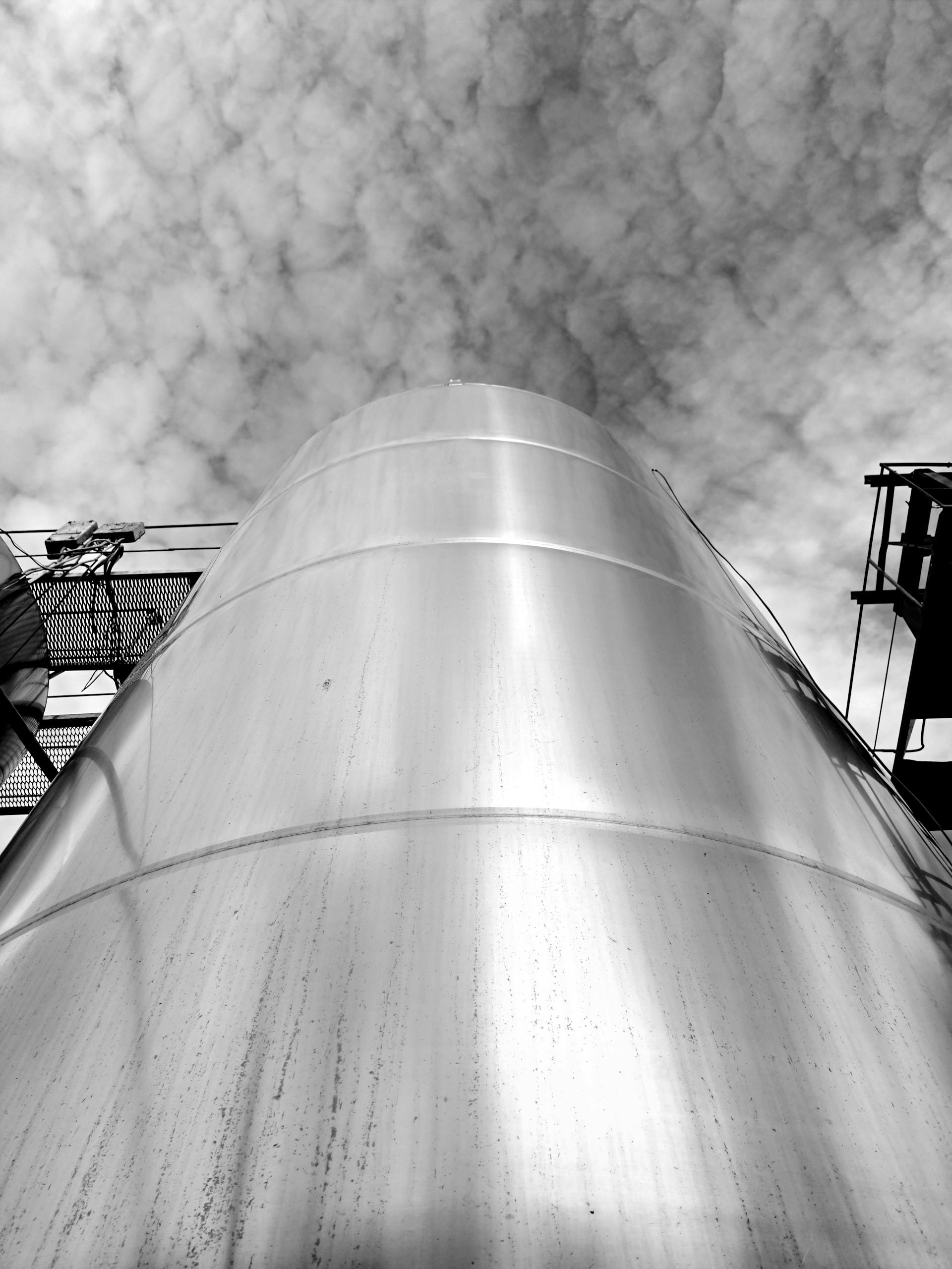 A striking black-and-white photo of a steel silo with a cloud-filled sky in Ukraine.