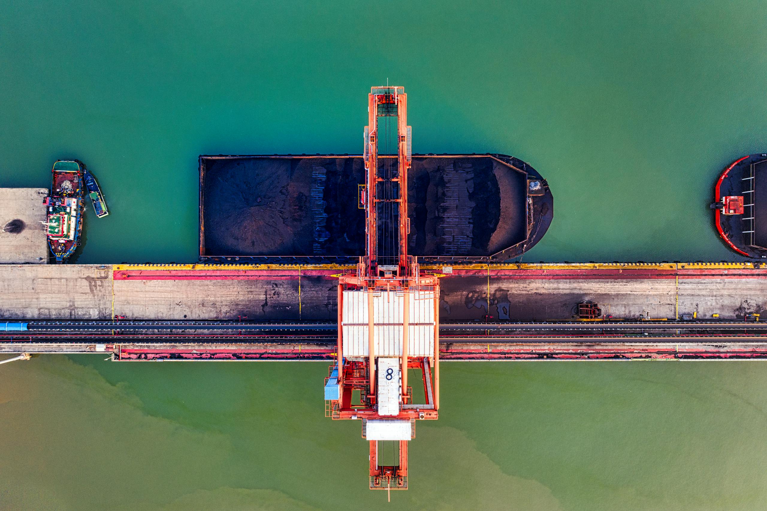 Aerial view of a cargo port with vessels and cranes in Banten, Indonesia.